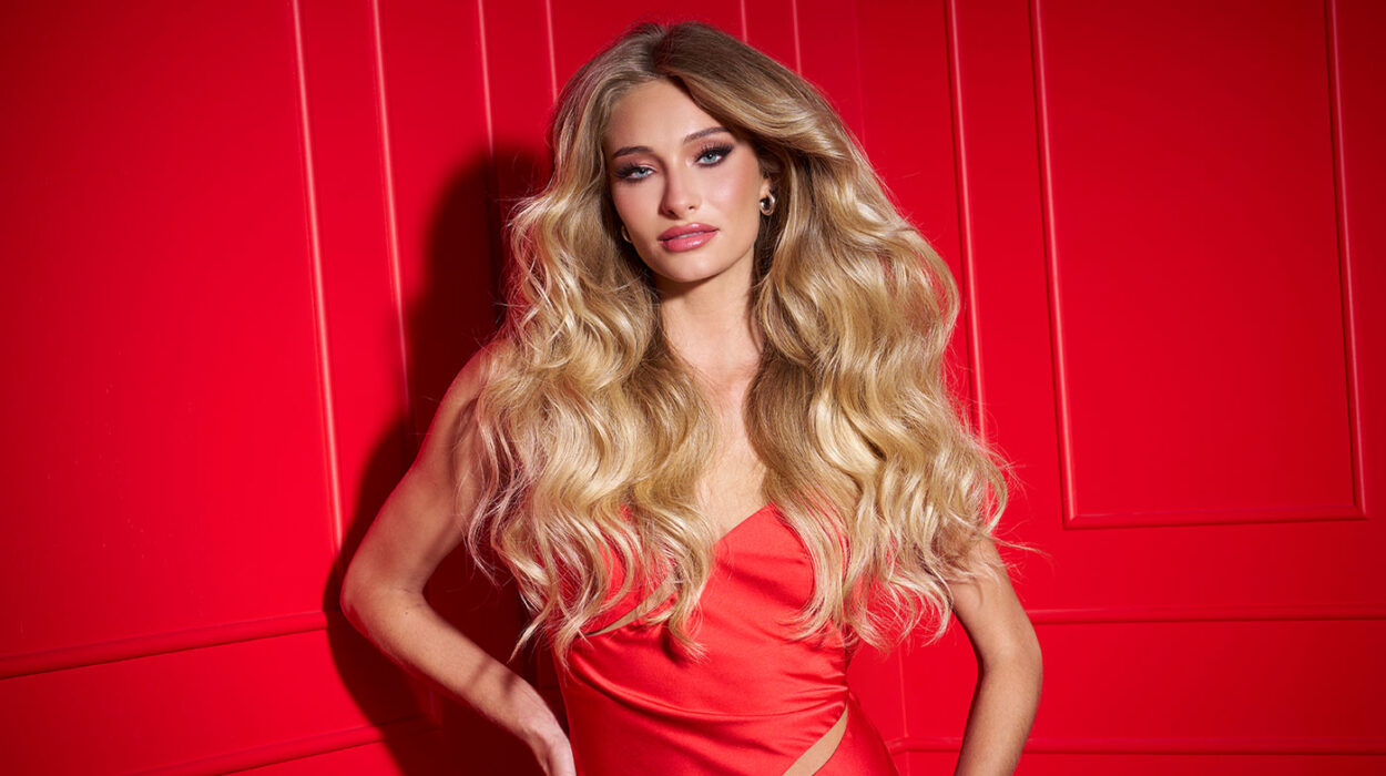 a female model with big sexy hair posing on a red background