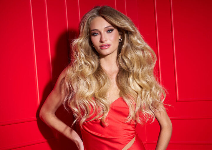 una modelo femenina con una gran melena sexy posando sobre un fondo rojo